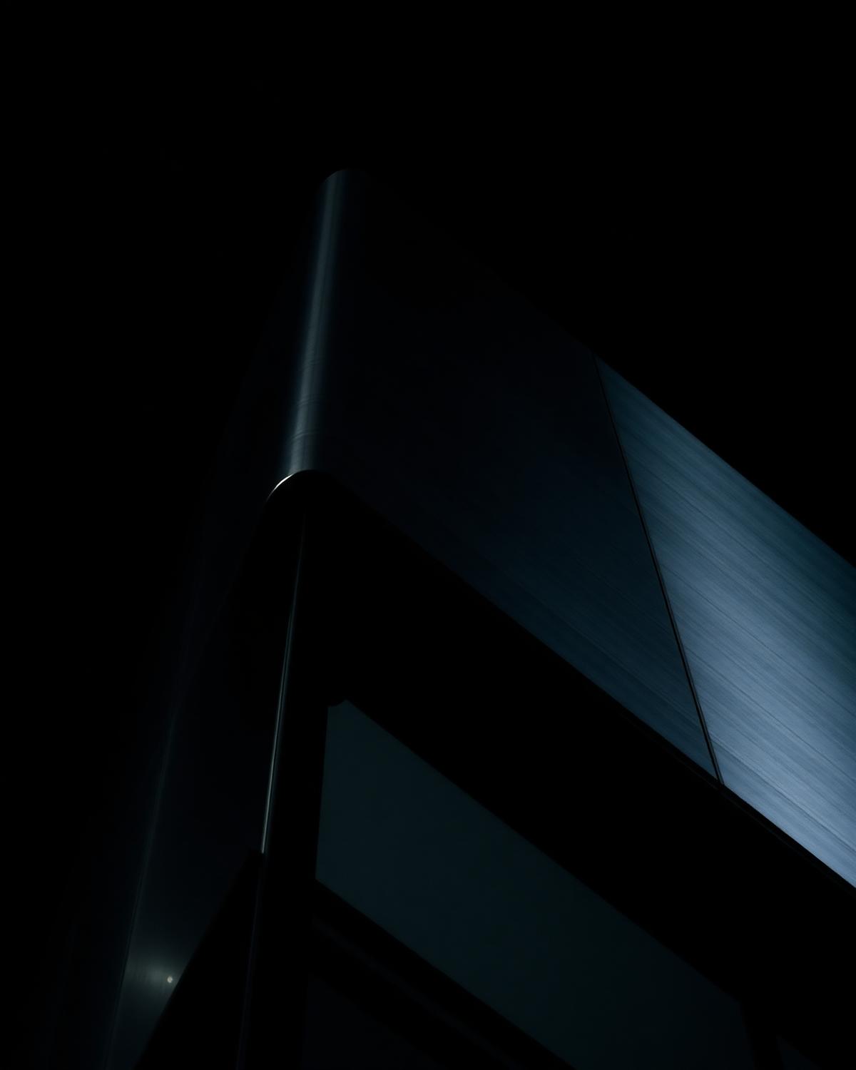 Brushed steel and black glass building corner at night
